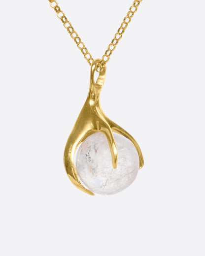 Yellow gold and pink tourmaline pendant necklace, close view of the gold claw cradling the round tourmaline