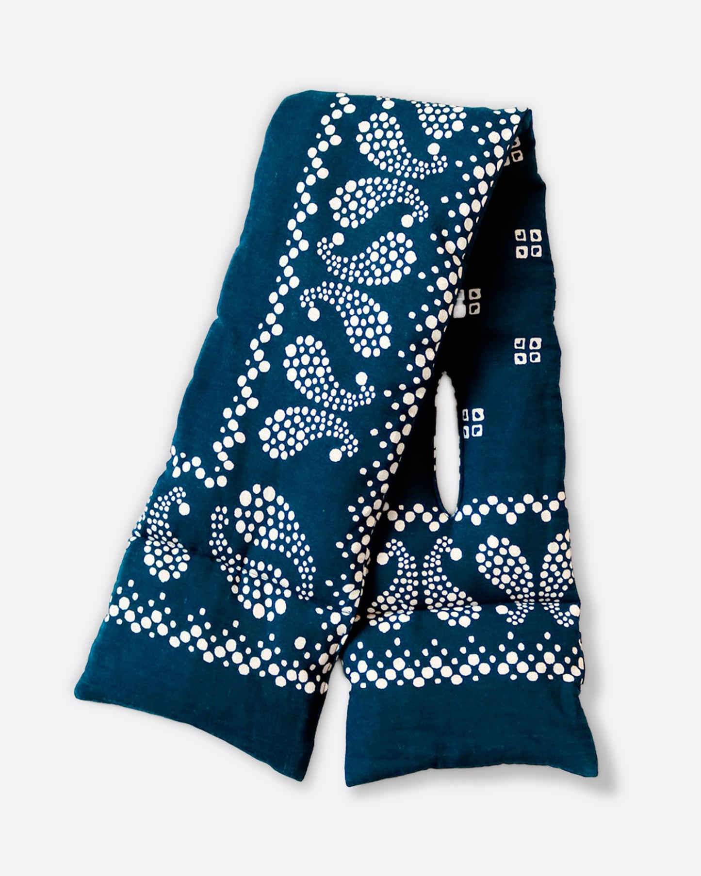 An insulated blue and white paisley printed bandana scarf with an opening at one end, shown folded in half.