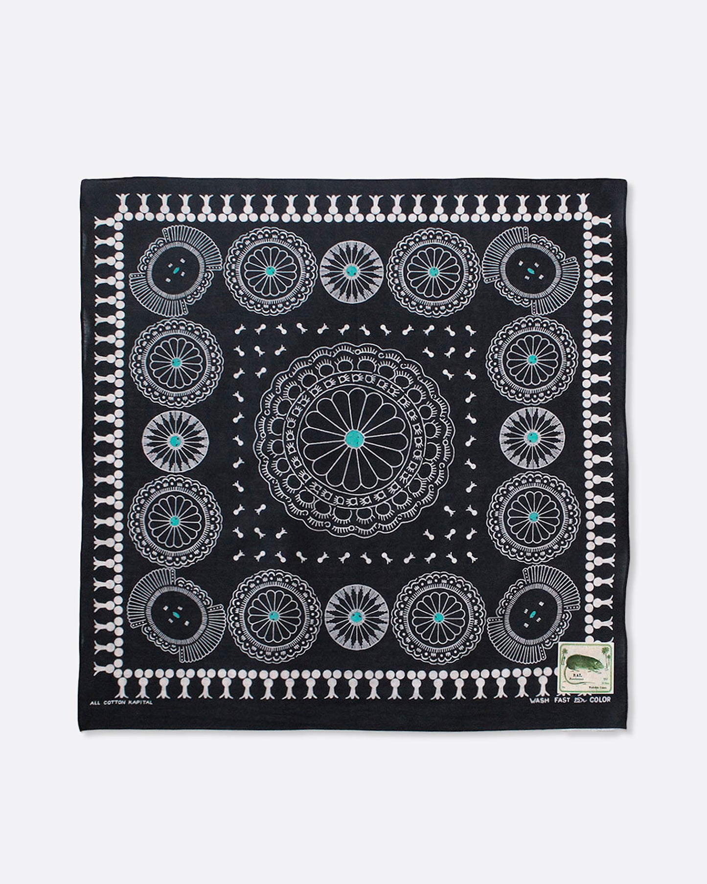 A black selvedge bandana with a pattern of turquoise- centered conchos. Shown lying flat.