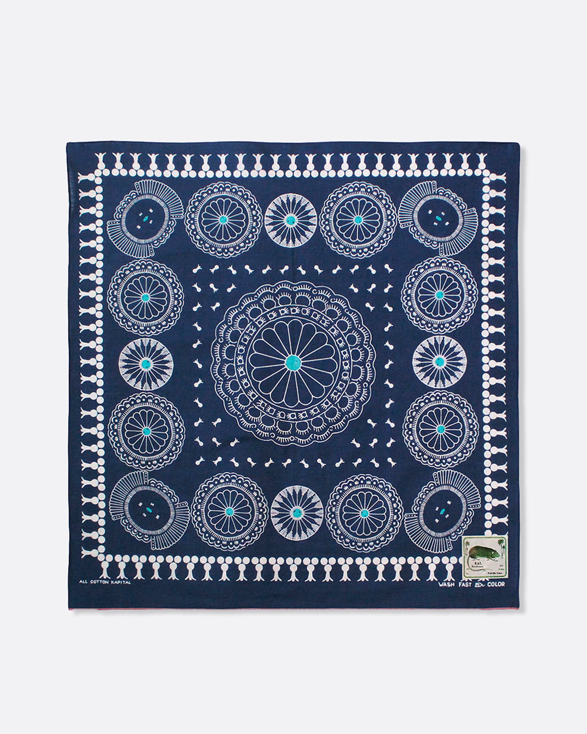 A navy selvedge bandana with a pattern of turquoise- centered conchos. Shown lying flat.