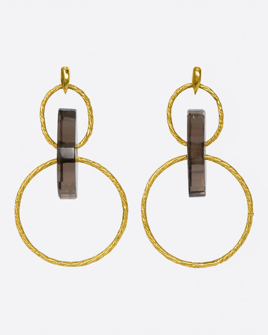 A pair of yellow gold stud earrings with two circular drops that are connected by smokey quartz beads.