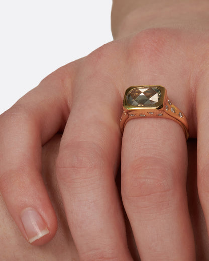 Yellow gold oval diamond ring worn on a hand, close up