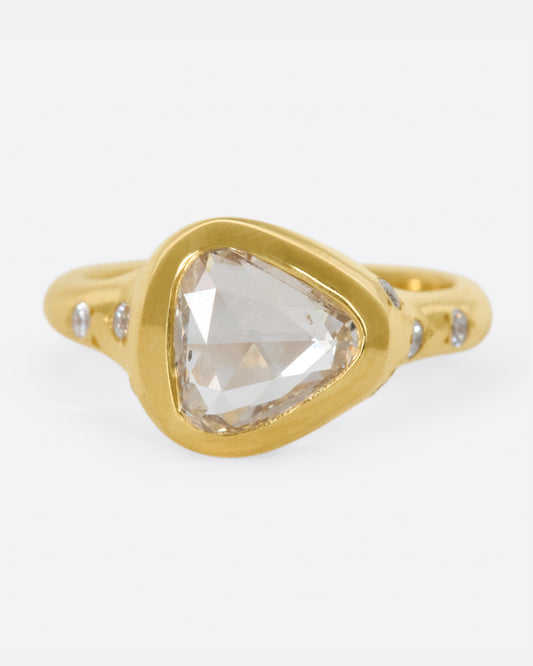 A glorious triangular, rose cut diamond sits on its side giving this ring an east-west sensibility.