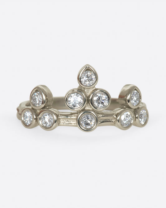 A tiara-like ring formed by 10 bezel-set round diamonds; wear it alone or stacked, and in either direction on the finger. 