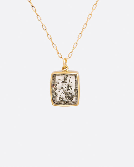 A yellow gold cable chain necklace with a quartz pendant with pyrite inclusions. Show from the front.
