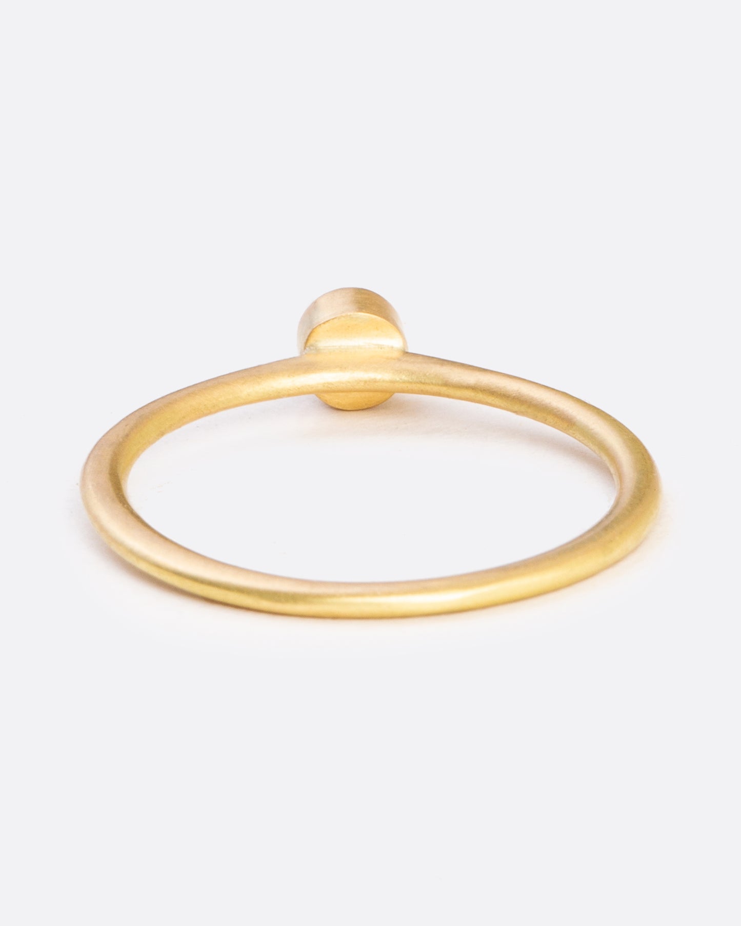 A yellow gold ring with a bezel set round diamond. Shown from the back.