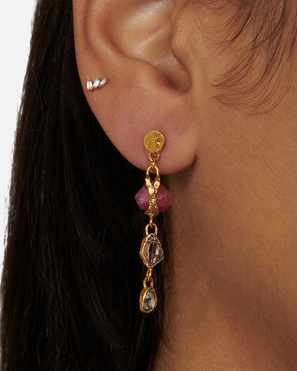 Yellow gold ruby and Herkimer diamond drop earrings worn on an ear