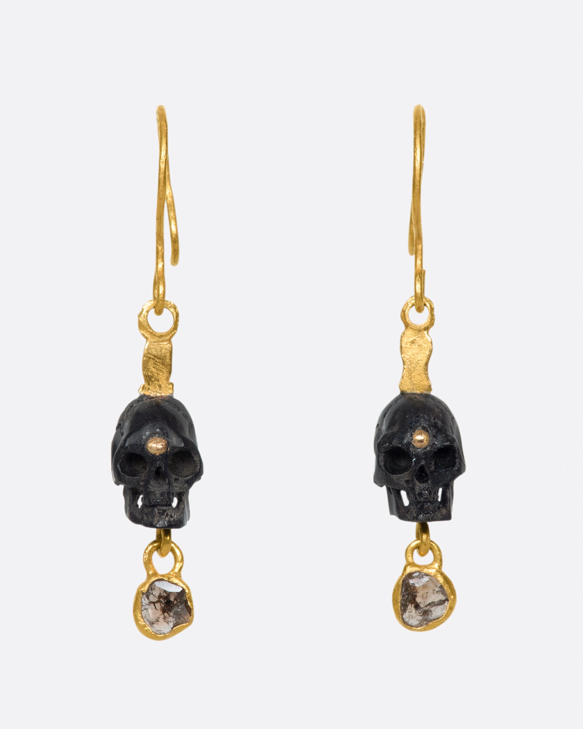 A pair of teeny, hand carved skulls with diamond dangles from Borneo.