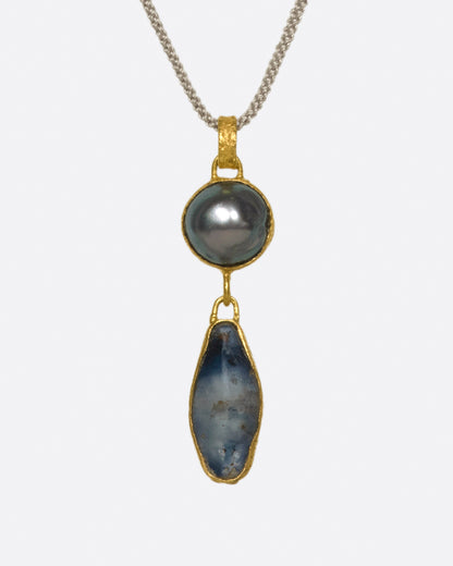 Lou Zeldis double drop pendant in 22k yellow gold on a gray cord, a Tahitian pearl above a long blue Sri Lankan sapphire, each wrapped in textured gold