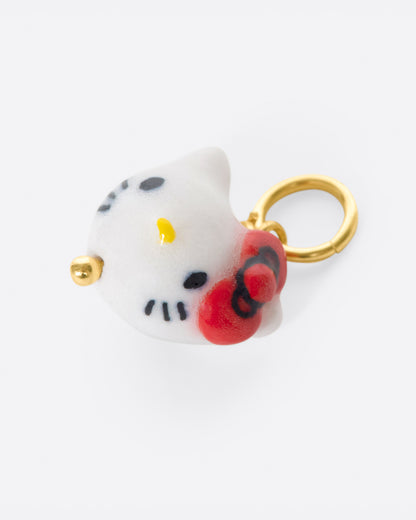 Porcelain cat face charm with red bow, angled view of the face