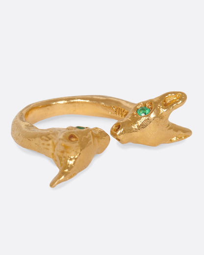 Yellow gold animal head ring with emerald eyes, side view showing one head with its emerald eye