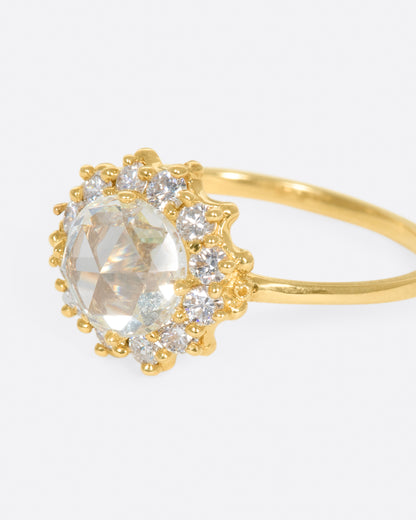 Yellow gold diamond halo ring, side view with the diamond flower facing left