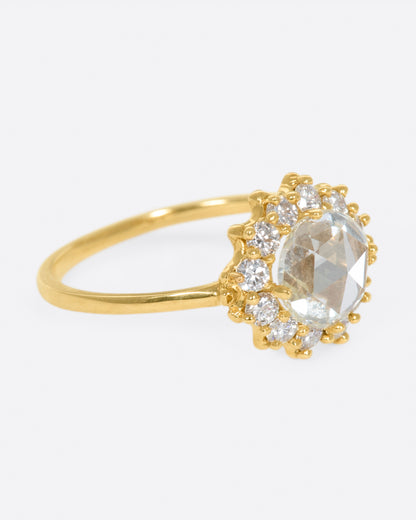 Yellow gold diamond halo ring, side view with the diamond flower facing right