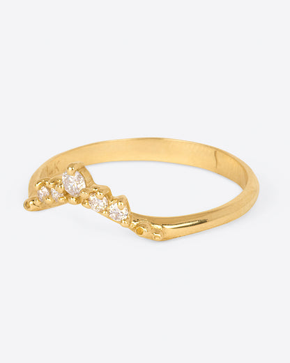 A yellow gold ring with an arched front and five diamonds. Shown from the side.
