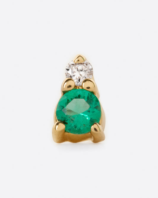 A yellow gold stud earring with a diamond on top and an emerald on the bottom. Shown from the front.