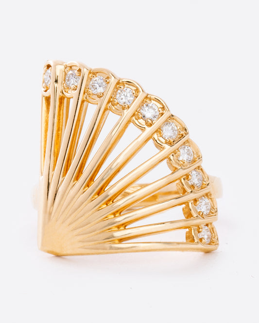 A yellow gold ring in the shape of a fan with diamonds along the top edge. Shown from the front.