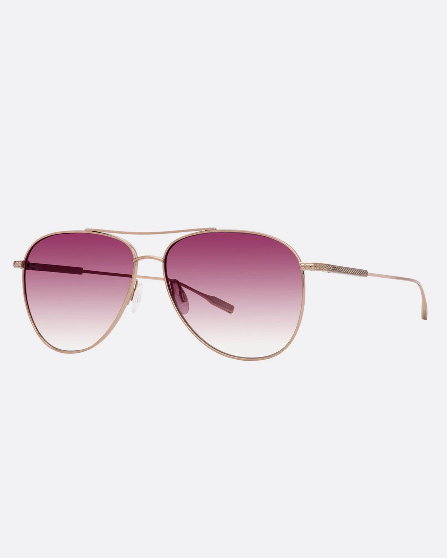 A pair of aviator sunglasses with pink gradient lenses. Shown diagonally from the front.