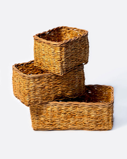 A stack of three rectangular vetiver baskets. Each basket is shown at a different angle from the side.