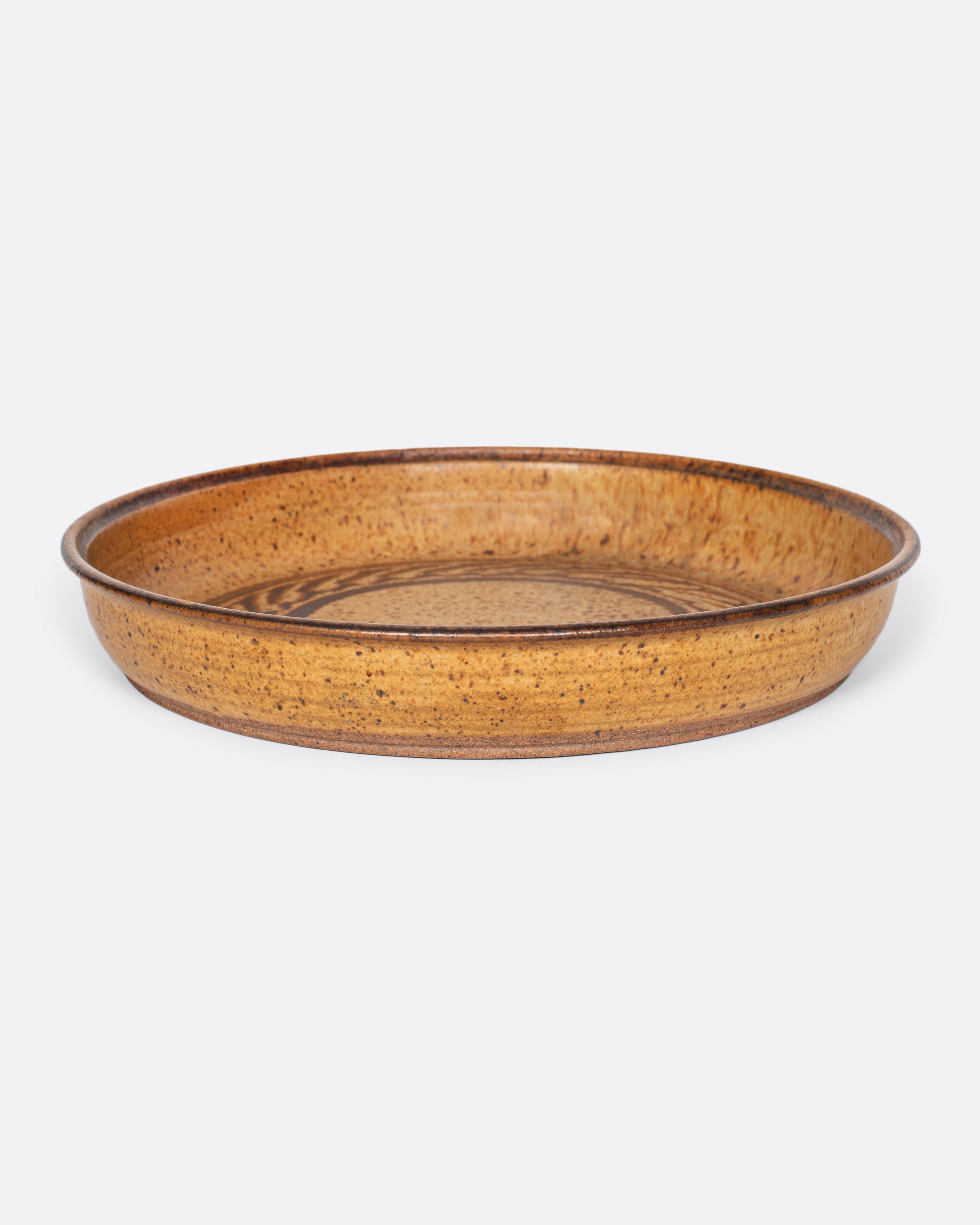 A vintage studio-made ceramic serving platter of generous size, with a swirling center design.