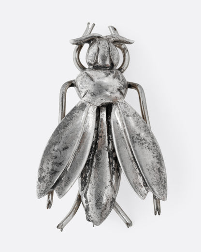 A silver wasp pin, shown from the front.