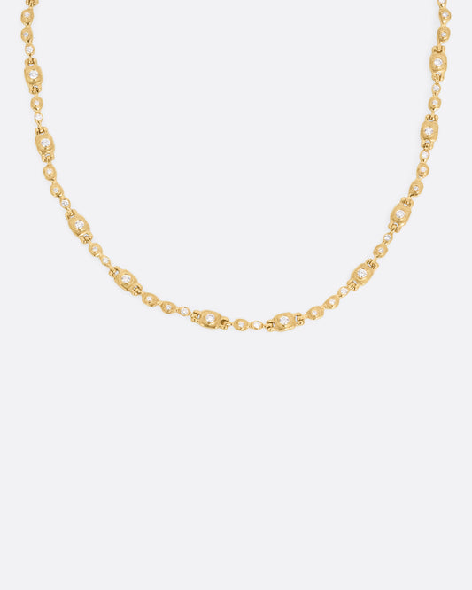 A yellow gold linked necklace with diamonds, shown from the front.