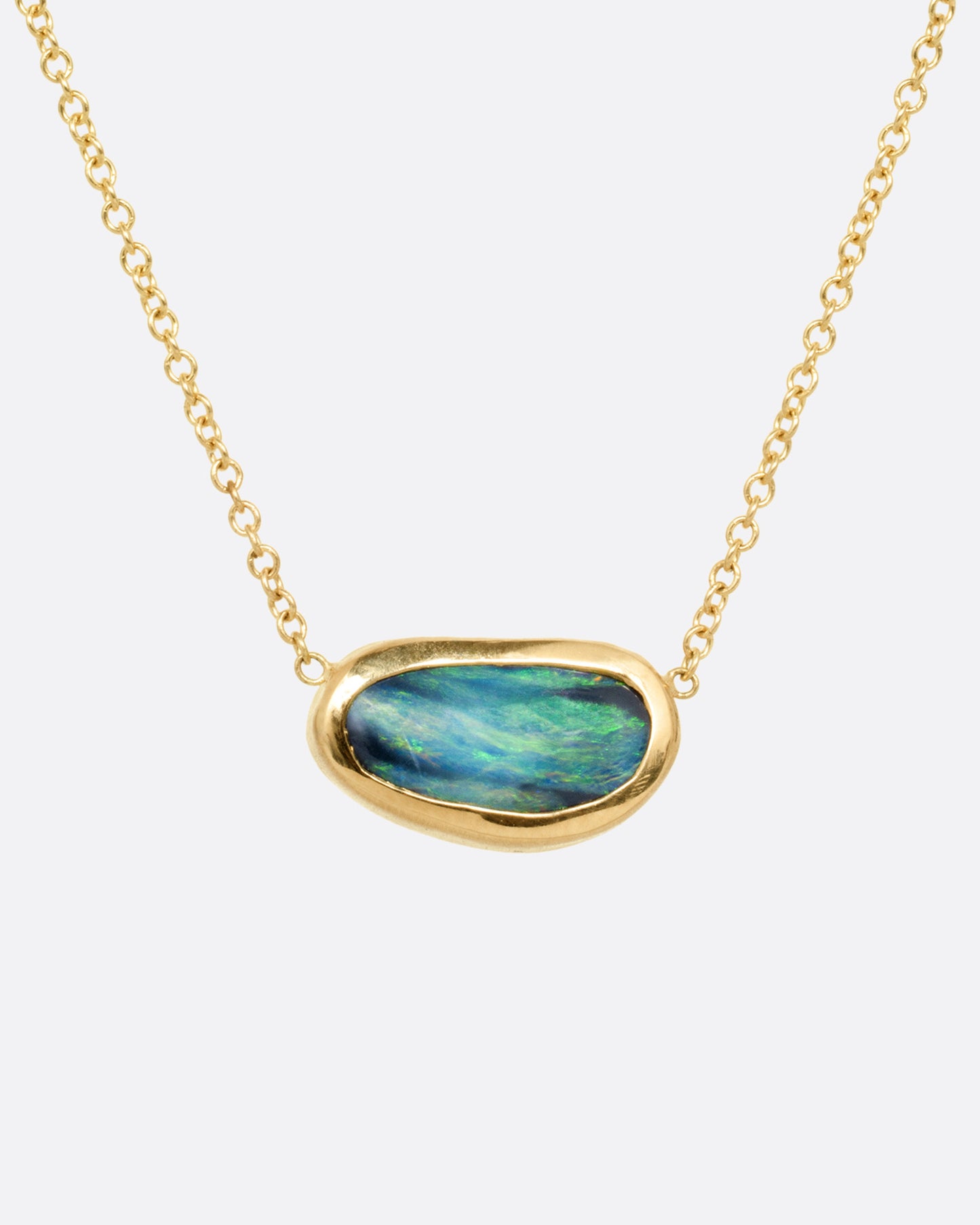 A yellow gold cable chain necklace with a blue-green Australian opal Shown from the front.