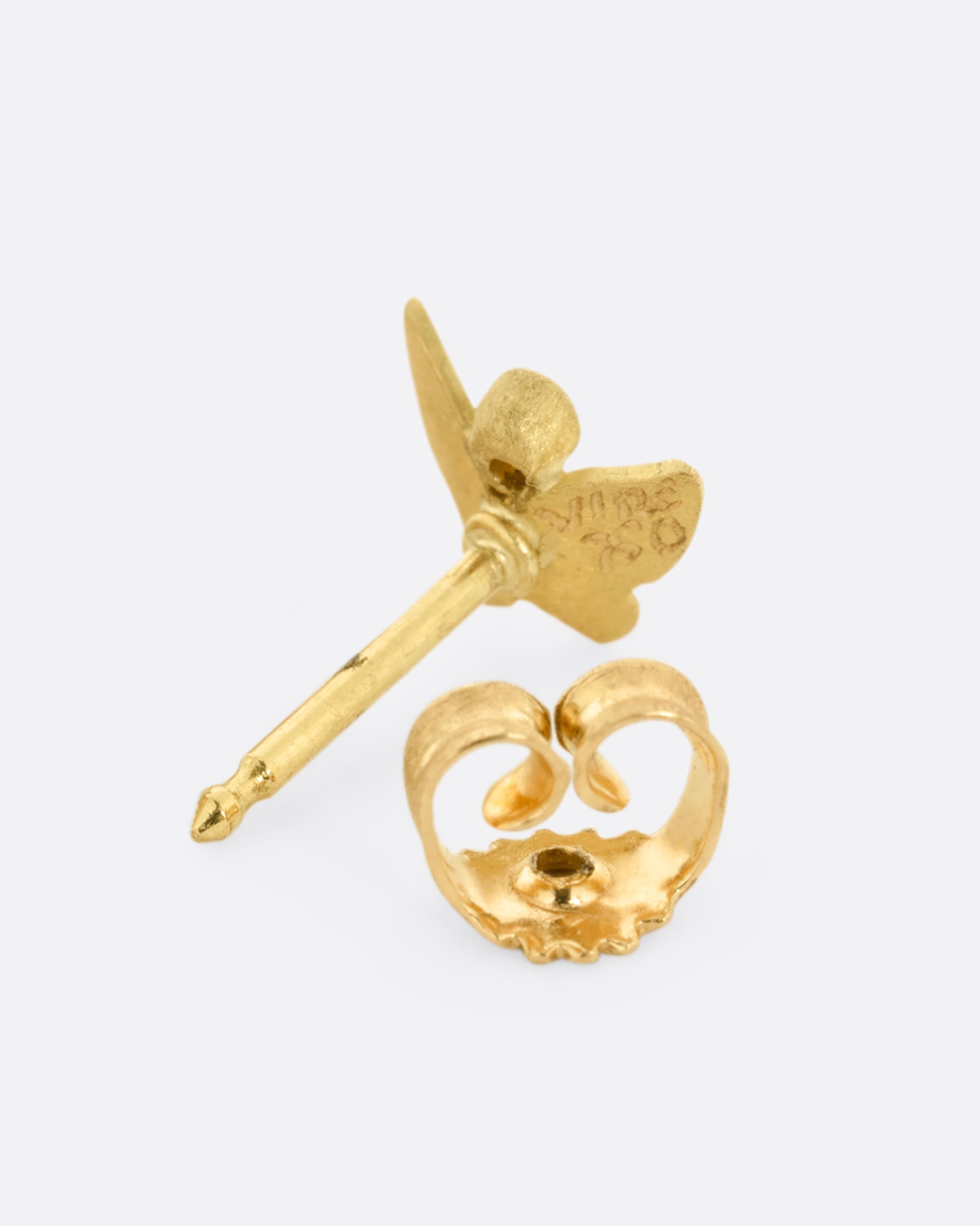 A yellow gold butterfly earring with a single diamond. Shown unclasped from the back.