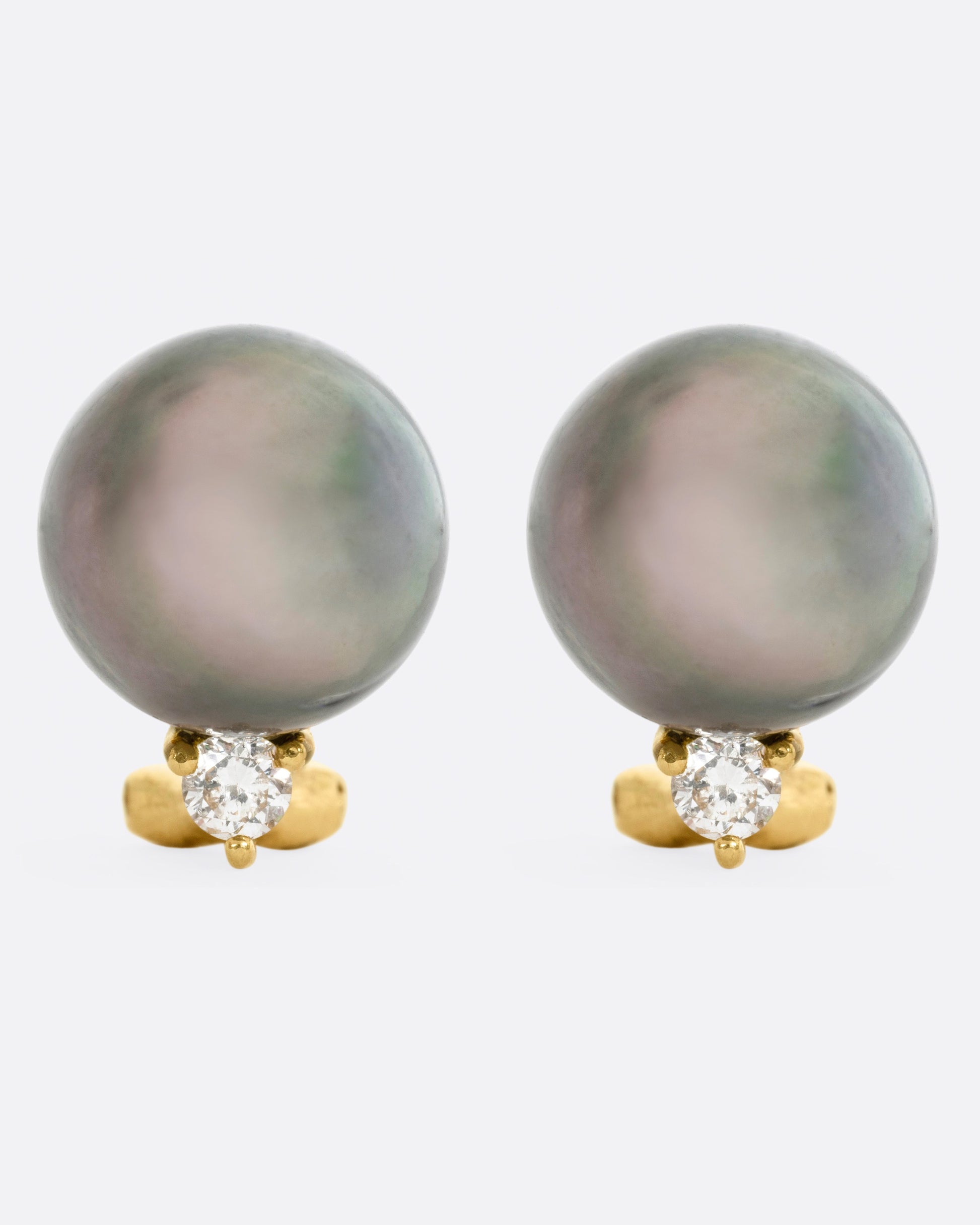 yellow gold earrings with a black pearl, and a white diamond, shown from the front