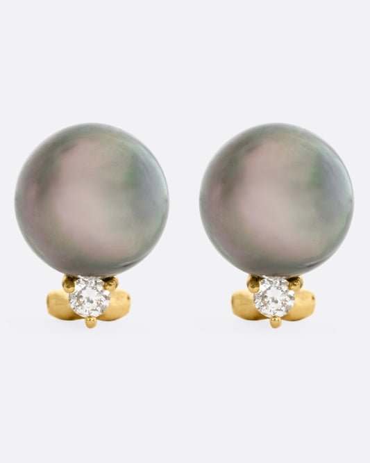 yellow gold earrings with a black pearl, and a white diamond, shown from the front