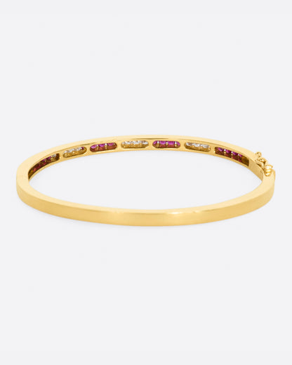 Yellow gold bracelet with alternating sections of channel set rubies and diamonds. View from the back.