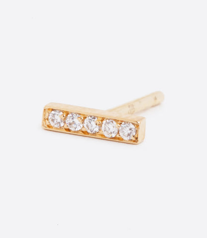 A yellow gold bar stud earring with five white diamonds. Shown lying on its side from the front.