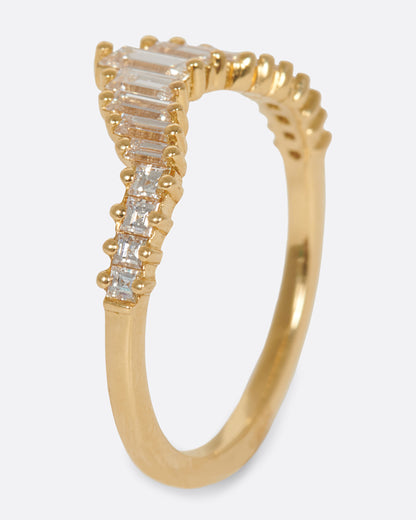 A curved crown ring lined with baguette diamonds. Shown from the side standing up.