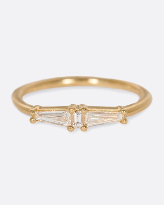 A ring featuring two tapered baguette diamonds and one carre cut diamond; perfect for stacking.