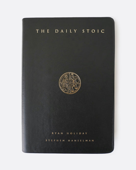 The front black leather cover of The Daily Stoic book. The cover reads in gold lettering: THE DAILY STOIC RYAN HOLIDAY STEPHEN HANSELMAN. It has a circular emblem in the center.