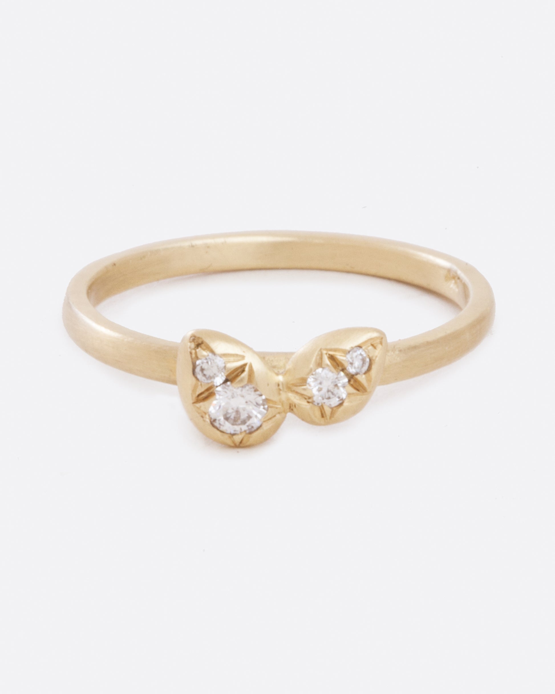 A yellow gold band with four asymmetrical diamonds stacked in a central geometric cluster. Shown from the front.