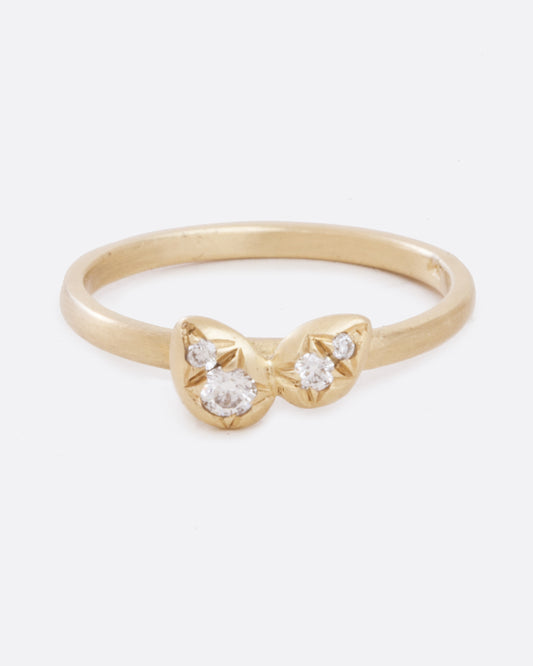 A yellow gold band with four asymmetrical diamonds stacked in a central geometric cluster. Shown from the front.