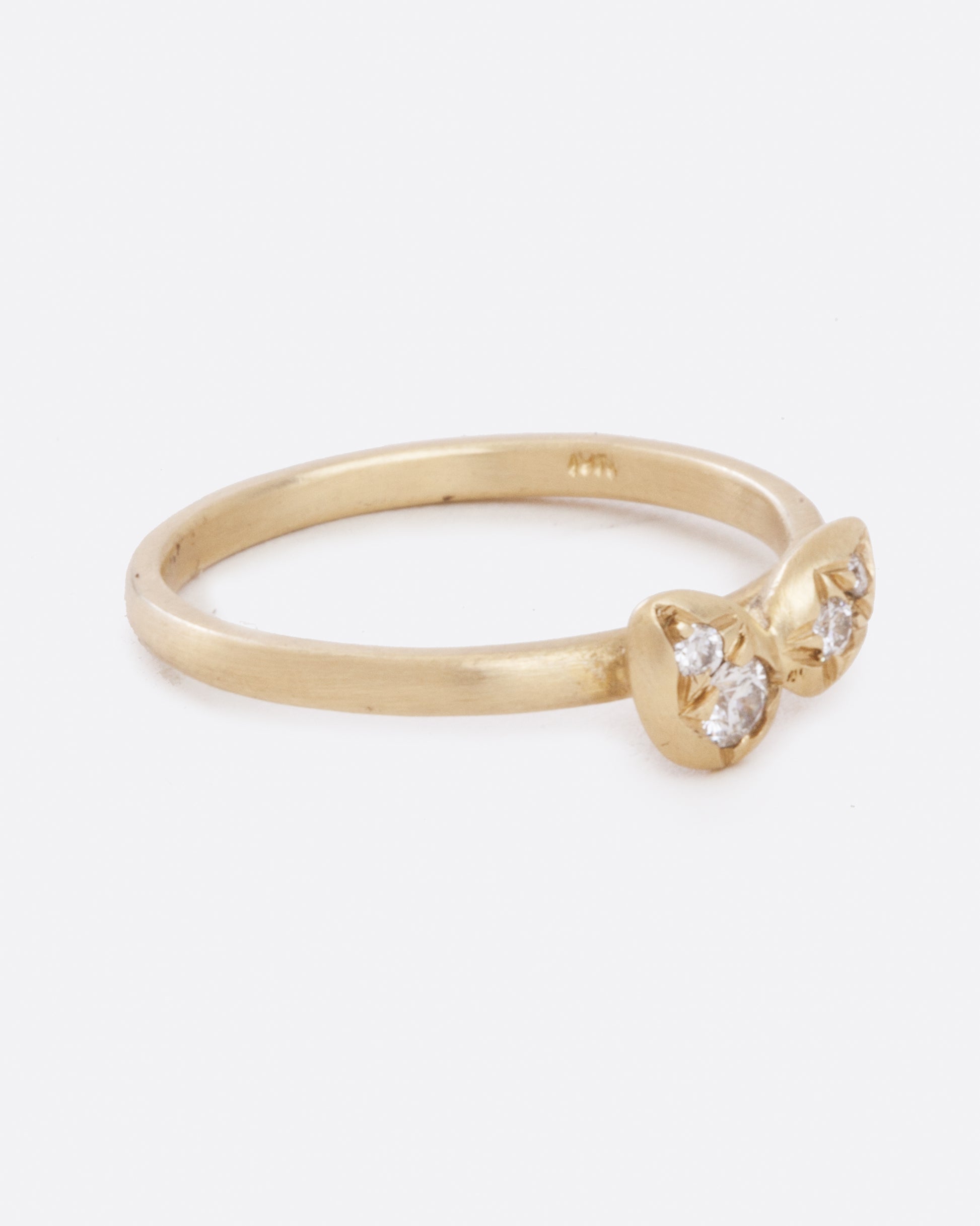 A yellow gold band with four asymmetrical diamonds stacked in a central geometric cluster. Shown from the side.
