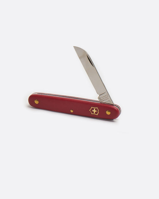 A Victorinox floral knife with red handle, shown standing up open from the side.