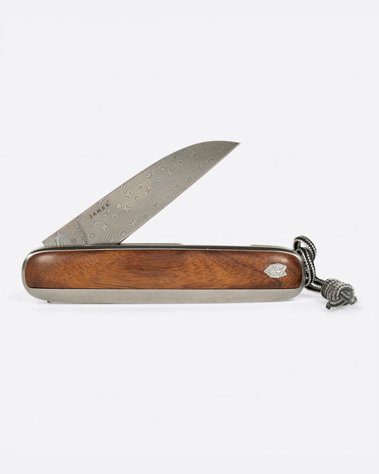 A pocket knife with a rosewood handle and damasteel blade. Shown from the side.