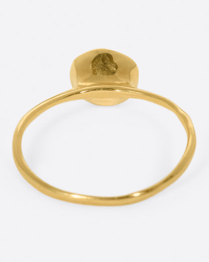 A yellow gold ring with a green tourmaline cabochon, shown from the back.