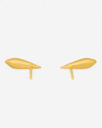 Yellow gold shell stud earrings, the pair from the side showing the posts