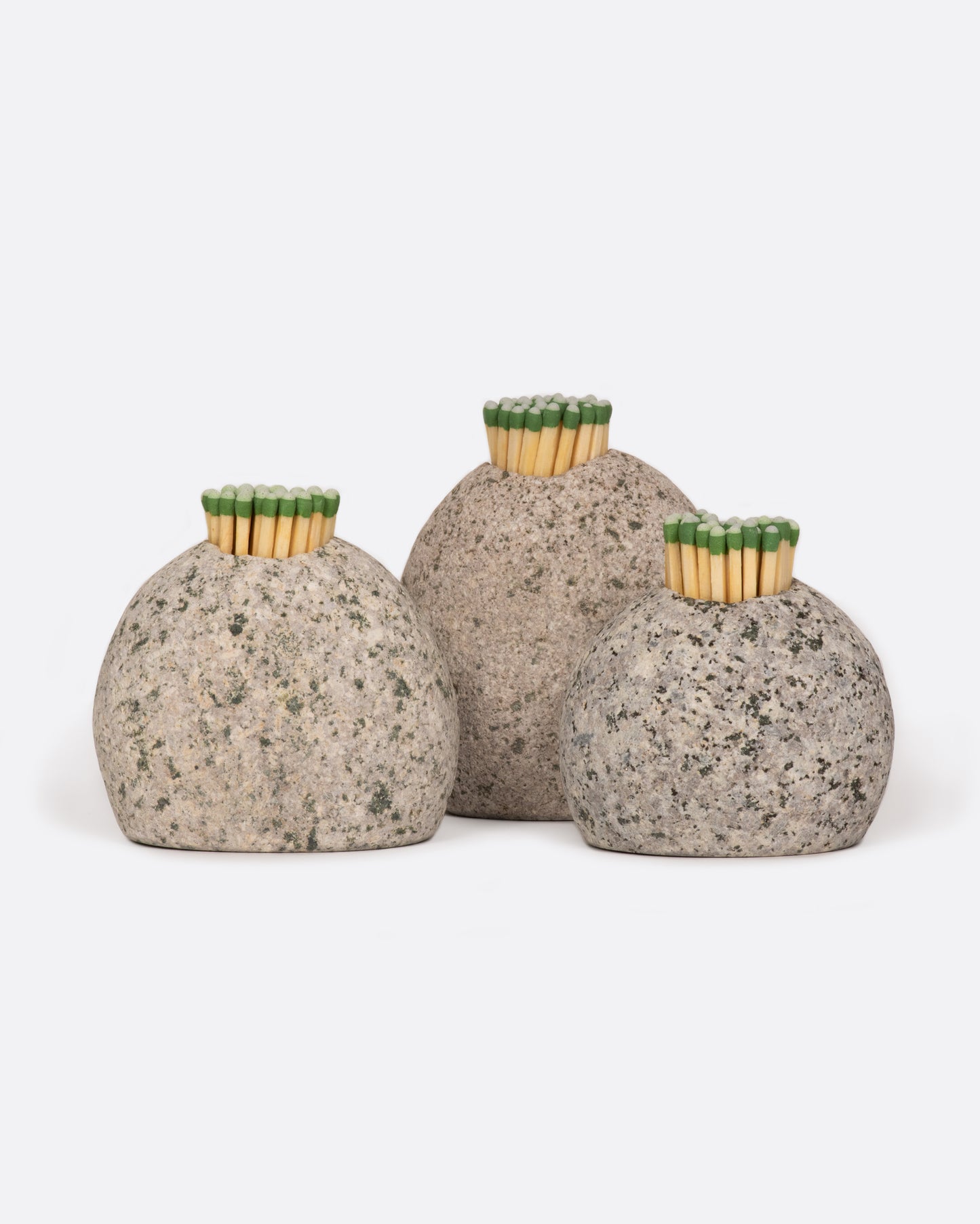 A group of three stone match strikers, shown with matches in them from the front.
