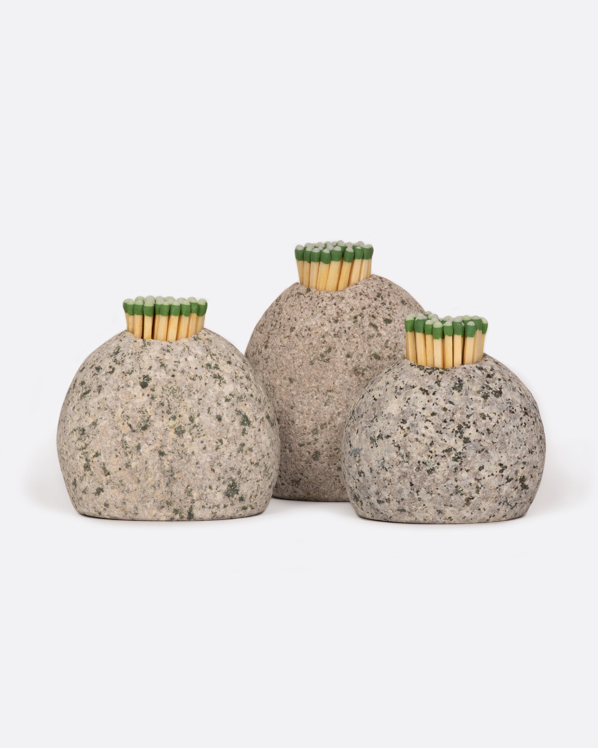 A group of three stone match strikers, shown with matches in them from the front.
