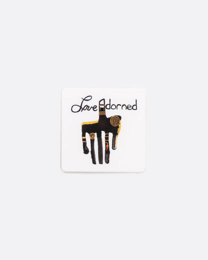 A square two inch gift card printed with a custom painting by love adorned founder of a primitive hand and the love adorned logo. Shown from the front.