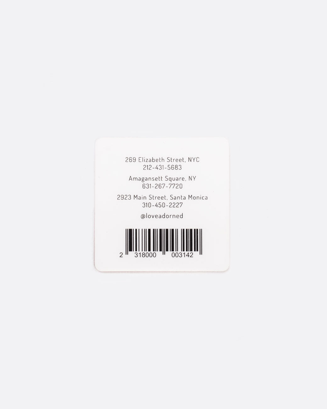 The back of a square 2" gift card with store informational details and a barcode.