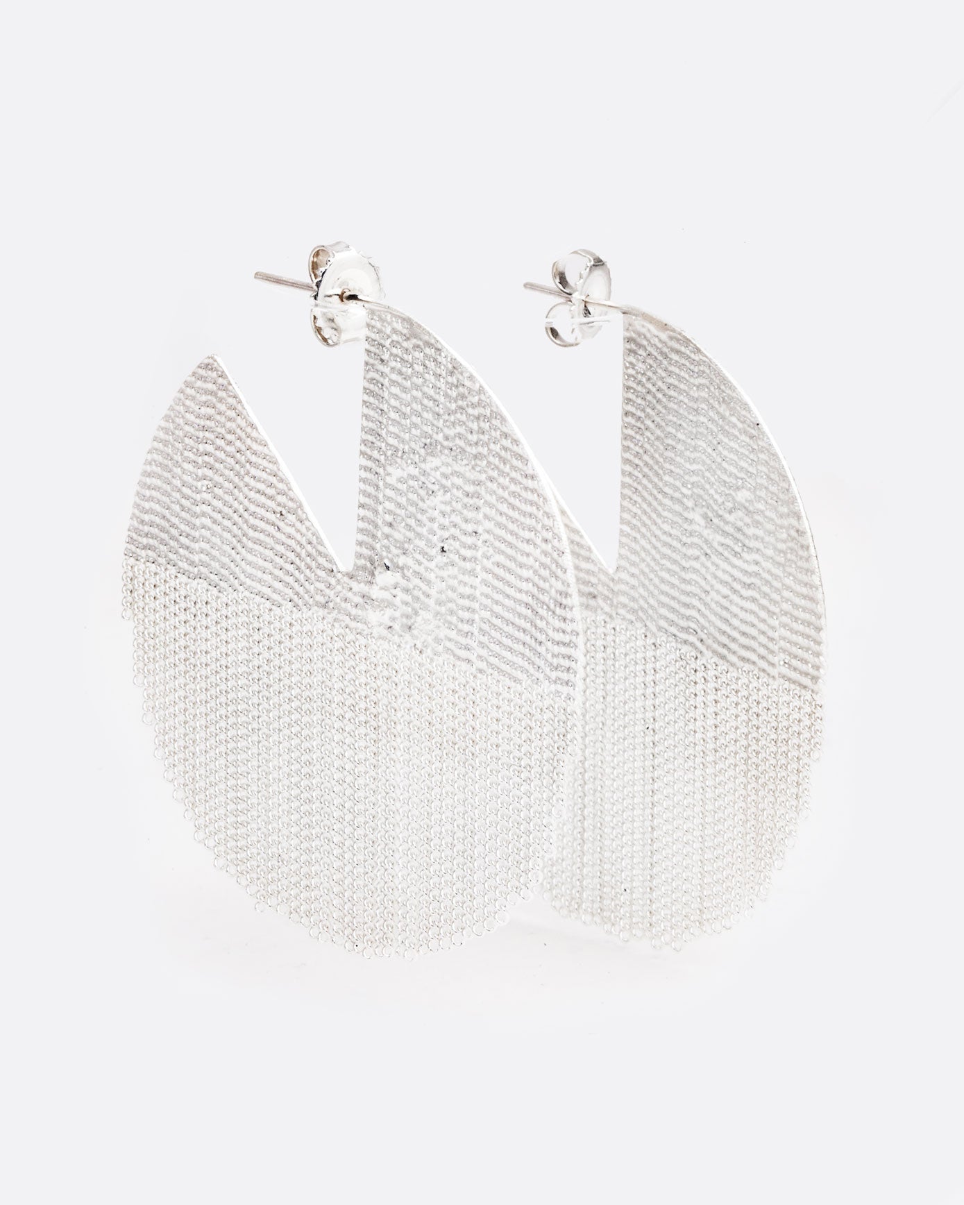 two large sterling silver earrings are hanging on a 45 degree angle. they are in a shape of a seven eighths of a circle, like one pie piece missing. The bottom half is made of chain and moves freely. There are posts and butterfly backings in the open piece of the circle.