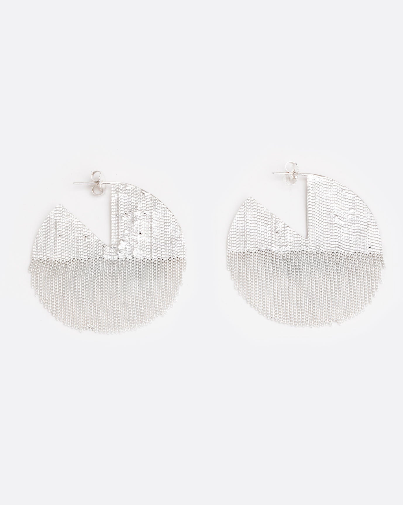 two large sterling silver earrings are laying on a white surface. they are in a shape of a seven eighths of a circle, like one pie piece missing. The bottom half is made of chain and moves freely. There are posts and butterfly backings in the open piece of the circle.
