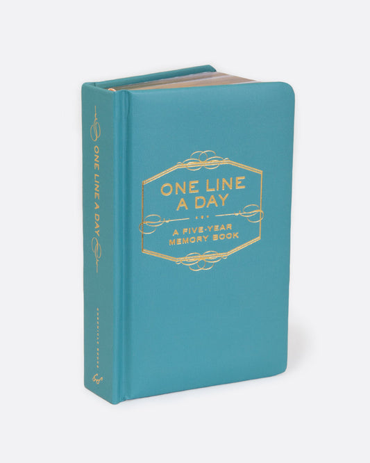 A teal book with gold pages and gold lettering on the cover reading: ONE LINE A DAY... A FIVE- YEAR MEMORY BOOK. Shown standing up from the front.