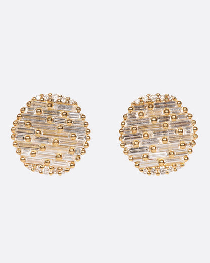 A pair of round yellow gold, slightly concave stud earrings covered in baguette diamonds. Shown from the front.