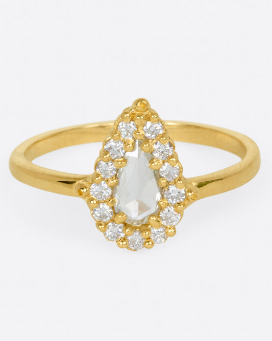 A yellow gold ring with a light champagne rose cut pear shaped diamond haloed by round diamonds. Shown from the front.